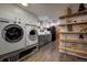 Functional laundry room with modern appliances and wooden shelves at 207 County Road 65, Evergreen, CO 80439