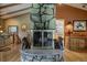 Open-concept living room featuring a unique stone fireplace and vaulted ceilings with wood beams at 207 County Road 65, Evergreen, CO 80439