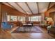 Bright living room with wood floors, exposed beams, and multiple windows offering scenic views at 207 County Road 65, Evergreen, CO 80439