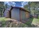 Exterior view of an outbuilding with painted wooden siding, wood doors, and an outdoor kennel at 207 County Road 65, Evergreen, CO 80439