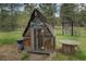 A small, rustic outbuilding with an A-frame roof and decorated with colorful rooster figures at 207 County Road 65, Evergreen, CO 80439