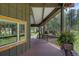 A covered patio featuring wood flooring, dark railings, outdoor lights, and a hanging fern basket at 207 County Road 65, Evergreen, CO 80439