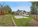 Spacious backyard featuring a well-maintained lawn, a basketball court, and a charming brick fence at 9451 W Hialeah Pl, Littleton, CO 80123
