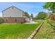 A vast backyard with lush green grass, garden bed and plenty of space for recreation or relaxation at 9451 W Hialeah Pl, Littleton, CO 80123
