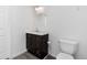 Bathroom featuring a dark wooden vanity with white countertop and a modern toilet at 9451 W Hialeah Pl, Littleton, CO 80123
