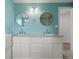 Bathroom featuring double sinks, a granite counter, and two round mirrors at 9451 W Hialeah Pl, Littleton, CO 80123