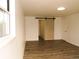 Bedroom with wood-look floors and a barn door adding a touch of rustic charm at 9451 W Hialeah Pl, Littleton, CO 80123