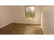 Bright bedroom featuring wood-look flooring and a large window for natural light at 9451 W Hialeah Pl, Littleton, CO 80123