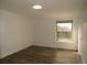 Cozy bedroom with neutral walls, wood-look floors, and a sunlit window view at 9451 W Hialeah Pl, Littleton, CO 80123