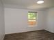Bedroom with a large window overlooking a fenced yard with fresh neutral paint and wood-look flooring at 9451 W Hialeah Pl, Littleton, CO 80123