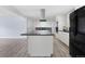 Modern kitchen featuring a large island, black appliances, and a view of the fireplace at 9451 W Hialeah Pl, Littleton, CO 80123