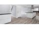 Open-concept kitchen with sleek white cabinetry, a large island, and new modern flooring at 9451 W Hialeah Pl, Littleton, CO 80123