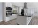 Modern kitchen boasts a center island, stainless vent hood, and stylish appliances at 9451 W Hialeah Pl, Littleton, CO 80123