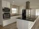 Well-lit kitchen with stainless steel appliances, an island, and modern cabinetry at 9451 W Hialeah Pl, Littleton, CO 80123