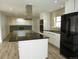 Modern kitchen featuring an island, stainless hood, sleek appliances, and updated cabinets at 9451 W Hialeah Pl, Littleton, CO 80123