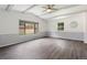 Vaulted living room with durable gray floors, large windows bringing light, and modern ceiling fan at 9451 W Hialeah Pl, Littleton, CO 80123