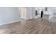 Bright living room featuring durable gray floors, a modern kitchen, and easy access to other parts of this lovely home at 9451 W Hialeah Pl, Littleton, CO 80123