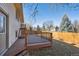 A wooden back deck features black iron railings and stairs to the backyard with a wood privacy fence at 7477 Holland Ct, Arvada, CO 80005