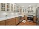 Bright kitchen featuring a farmhouse sink, modern appliances, white backsplash, and hardwood floors at 705 S Alton Way # 4D, Denver, CO 80247
