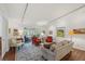 Bright living room with track lighting, gray sofa, orange chairs, and sliding glass doors to the outdoor area at 705 S Alton Way # 4D, Denver, CO 80247