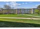 A three-story apartment building featuring well-maintained landscaping and a lush green lawn on a sunny day at 655 S Alton Way # 8D, Denver, CO 80247