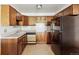 Traditional kitchen featuring wood cabinets, stainless steel sink, and black refrigerator at 655 S Alton Way # 8D, Denver, CO 80247
