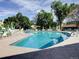 Bright, sunny pool area surrounded by trees, lounge chairs, and umbrellas at 655 S Alton Way # 8D, Denver, CO 80247