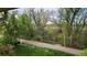 Balcony view featuring a paved path with lush green foliage and mature trees at 655 S Alton Way # 8D, Denver, CO 80247
