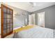Bedroom featuring hardwood floors, ceiling fan, gray walls, and doors to an en suite and walk in closet at 3044 W 40Th Ave, Denver, CO 80211