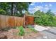 Detached garage with a wooden door, wooden fence, and some plants at 3044 W 40Th Ave, Denver, CO 80211