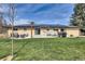 A large backyard with patio furniture, green grass and solar panels for energy efficiency at 16816 E Costilla Ave, Foxfield, CO 80016