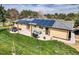 Spacious backyard with a patio, featuring solar panels on the roof and mature trees at 16816 E Costilla Ave, Foxfield, CO 80016