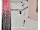 Bright bathroom featuring a shower and tub combo with white subway tile and pink accent wall at 16816 E Costilla Ave, Foxfield, CO 80016