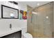Modern bathroom featuring gray tile, walk-in shower with glass door, and sleek vanity at 16816 E Costilla Ave, Foxfield, CO 80016