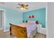 Charming bedroom with light blue walls, wood trim, a ceiling fan, and a view from the window at 16816 E Costilla Ave, Foxfield, CO 80016