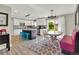 Bright eat-in kitchen with center island, white cabinets, and light wood floors open to dining area at 16816 E Costilla Ave, Foxfield, CO 80016
