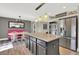 Bright kitchen with stainless appliances, granite counters, center island, and dining nook with pink banquette at 16816 E Costilla Ave, Foxfield, CO 80016