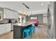 Charming kitchen featuring stainless steel appliances, gray island, and seating overlooking the back yard at 16816 E Costilla Ave, Foxfield, CO 80016
