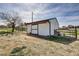 Exterior of a white shed with a sliding door and a rustic fence, offering ample storage space at 16816 E Costilla Ave, Foxfield, CO 80016