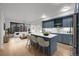 Open-concept kitchen with blue cabinetry, a marble island, and bar stool seating at 1750 Wewatta St # 1227, Denver, CO 80202