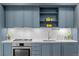 Close-up of a modern kitchen with blue cabinets, white subway tile backsplash, and stainless steel oven at 1750 Wewatta St # 1227, Denver, CO 80202