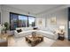 Bright living room featuring a large sectional sofa, wood coffee table, and expansive city views at 1750 Wewatta St # 1227, Denver, CO 80202