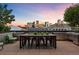 Rooftop patio with outdoor kitchen setup and panoramic views of the Denver skyline at dusk at 1750 Wewatta St # 1227, Denver, CO 80202