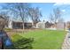 Spacious backyard featuring a well-maintained turf area, mature trees, storage shed, and a detached garage at 4546 S Logan St, Englewood, CO 80113