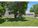 Spacious backyard with green lawn, mature tree and partial view of a detached garage/shed at 4546 S Logan St, Englewood, CO 80113