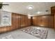 Carpeted basement with wood paneling and natural light shining through multiple windows at 4546 S Logan St, Englewood, CO 80113