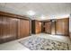 Wood-paneled basement featuring carpet flooring, storage closets, and an access to a utility area at 4546 S Logan St, Englewood, CO 80113