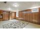 Spacious basement with wood paneling, carpet flooring, and a couple of windows providing natural light at 4546 S Logan St, Englewood, CO 80113