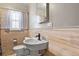 Bathroom featuring wood paneling, updated sink, stylish faucet, and a window for natural light at 4546 S Logan St, Englewood, CO 80113