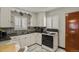 Charming kitchen with white cabinets, marble floors, stainless steel sink, and gas range stove at 4546 S Logan St, Englewood, CO 80113